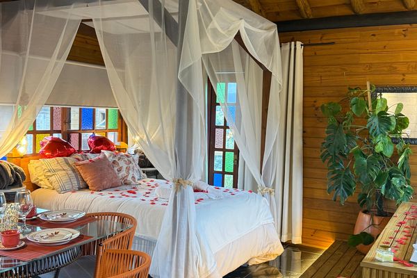 Cama com dossel e mesa no interior do chalé | Chalé Boutique dos Sonhos - Praia do Rosa/SC