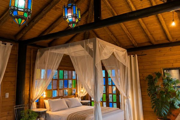 Cama com dossel e detalhes do teto de madeira | Chalé Boutique dos Sonhos - Praia do Rosa/SC