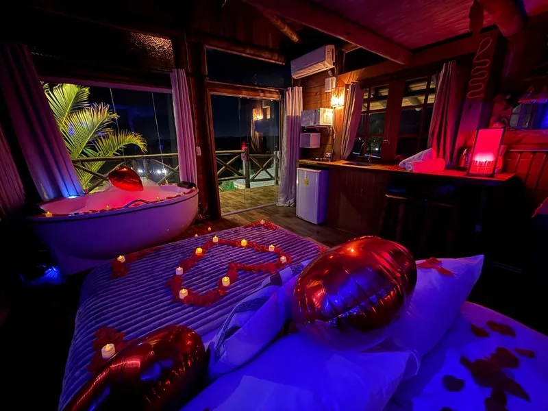 Cama e hidromassagem com decoração romântica à noite