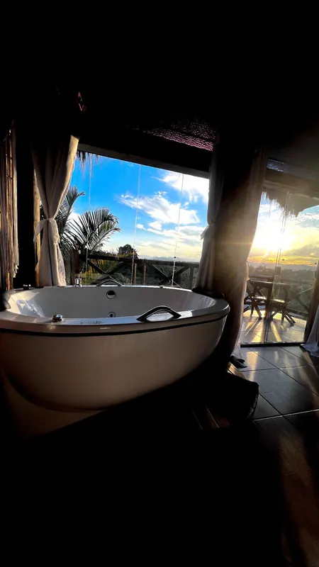 Vista da banheira com o pôr do sol ao fundo