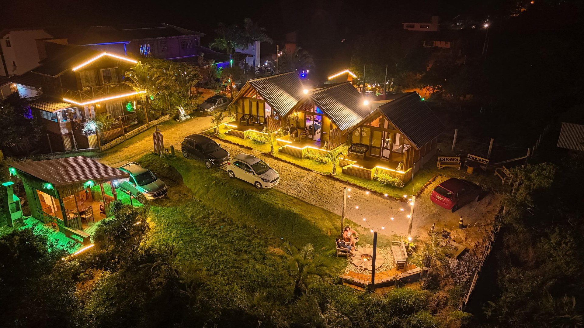 Vista aérea noturna dos chalés iluminados da Pousada Bangalô House